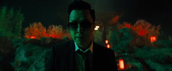Movie still from “John Wick: Chapter 4” (2023), directed by Chad Stahelski – A man wearing a suit and sunglasses in a dark room; Close Up shot, Low angle