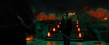 Movie still from “John Wick: Chapter 4” (2023), directed by Chad Stahelski – A man in a suit and tie holding a sword; Wide shot, Over the shoulder angle