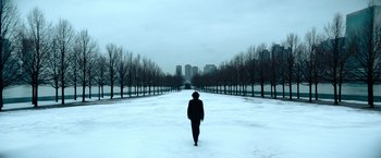 Movie still from “John Wick: Chapter 4” (2023), directed by Chad Stahelski – A person is walking in the middle of a snow covered park; Extreme Wide shot, High angle