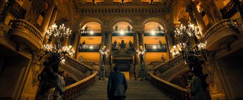 Movie still from “John Wick: Chapter 4” (2023), directed by Chad Stahelski – A man standing in front of a staircase in a building; Extreme Wide shot, Low angle