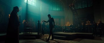 Movie still from “John Wick: Chapter 4” (2023), directed by Chad Stahelski – A man walking in front of an audience in front of a crowd of onlookers; Wide shot, Low angle