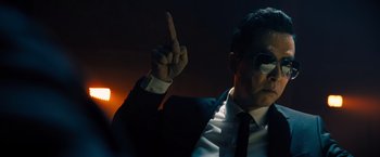 Movie still from “John Wick: Chapter 4” (2023), directed by Chad Stahelski – A man in a suit and tie holding up a finger; Close Up shot, Low angle