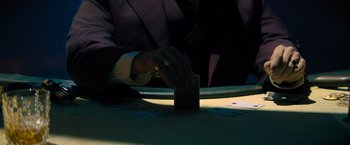 Movie still from “John Wick: Chapter 4” (2023), directed by Chad Stahelski – A man in a suit is playing a card game; Extreme Close Up shot, High angle