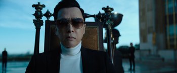 Movie still from “John Wick: Chapter 4” (2023), directed by Chad Stahelski – A man in a suit and sunglasses sitting in a chair; Close Up shot, Low angle