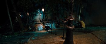 Movie still from “John Wick: Chapter 4” (2023), directed by Chad Stahelski – A night scene of an alley way with lights and trees; Extreme Wide shot, High angle