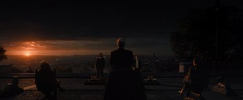 Movie still from “John Wick: Chapter 4” (2023), directed by Chad Stahelski – Two men standing on a hill overlooking a city at night; Extreme Wide shot, Over the shoulder angle