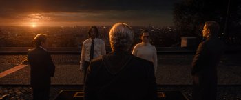 Movie still from “John Wick: Chapter 4” (2023), directed by Chad Stahelski – Three people standing on a roof top at sunset; Medium shot, Over the shoulder angle
