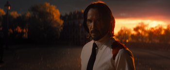 Movie still from “John Wick: Chapter 4” (2023), directed by Chad Stahelski – A man in a white dress shirt and a tie; Medium shot, Low angle