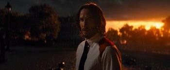 Movie still from “John Wick: Chapter 4” (2023), directed by Chad Stahelski – A man in a white shirt and a black neck tie; Medium shot, Low angle