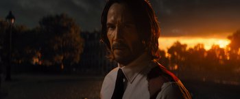 Movie still from “John Wick: Chapter 4” (2023), directed by Chad Stahelski – A person wearing a suit and tie; Close Up shot, Low angle