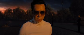 Movie still from “John Wick: Chapter 4” (2023), directed by Chad Stahelski – A man wearing sunglasses and a white t - shirt; Close Up shot, Low angle