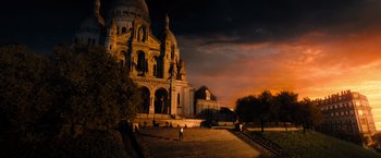 Movie still from “John Wick: Chapter 4” (2023), directed by Chad Stahelski – A person standing in front of a large building; Extreme Wide shot, High angle