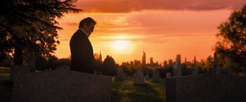 Movie still from “John Wick: Chapter 4” (2023), directed by Chad Stahelski – A man standing in front of a sunset in a cemetery; Wide shot, Low angle