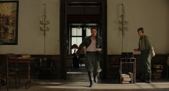 Movie still from “Jojo Rabbit” (2019), directed by Taika Waititi – A man walking through a room holding a knife; Wide shot, Low angle