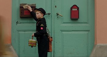 Movie still from “Jojo Rabbit” (2019), directed by Taika Waititi – A boy in a uniform is standing in front of a green door; Medium shot, High angle