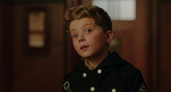 Movie still from “Jojo Rabbit” (2019), directed by Taika Waititi – A young boy wearing a black jacket and a white shirt; Close Up shot, Over the shoulder angle