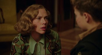 Movie still from “Jojo Rabbit” (2019), directed by Taika Waititi – A woman in a green jacket is looking at the camera; Close Up shot, Over the shoulder angle