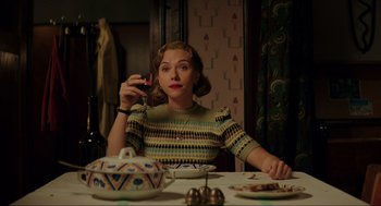 Movie still from “Jojo Rabbit” (2019), directed by Taika Waititi – A woman sitting at a table holding a cell phone to her ear; Medium shot, Low angle