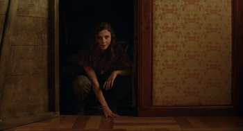 Movie still from “Jojo Rabbit” (2019), directed by Taika Waititi – A woman crouching down in a room with wood floors; Medium shot, Low angle