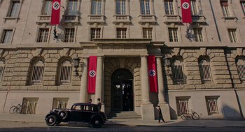 Movie still from “Jojo Rabbit” (2019), directed by Taika Waititi – A building that has a car parked in front of it; Extreme Wide shot, Low angle