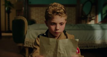 Movie still from “Jojo Rabbit” (2019), directed by Taika Waititi – A young boy in uniform holding a piece of paper; Close Up shot, High angle