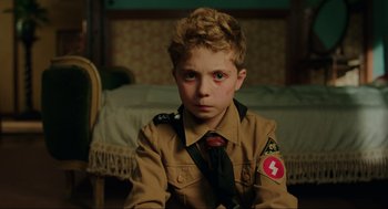Movie still from “Jojo Rabbit” (2019), directed by Taika Waititi – A young boy in a uniform with a tie; Close Up shot, High angle