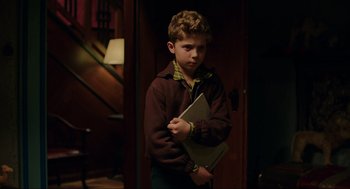 Movie still from “Jojo Rabbit” (2019), directed by Taika Waititi – A young boy holding a book in his hands; Medium shot, High angle