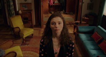 Movie still from “Jojo Rabbit” (2019), directed by Taika Waititi – A woman with long brown hair standing in a living room; Medium shot, High angle