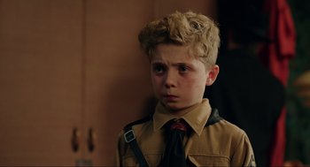 Movie still from “Jojo Rabbit” (2019), directed by Taika Waititi – A young boy in a brown jacket and a red tie; Close Up shot, Over the shoulder angle