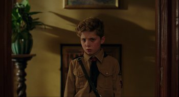 Movie still from “Jojo Rabbit” (2019), directed by Taika Waititi – A young boy in a brown shirt and a tie; Close Up shot, Over the shoulder angle