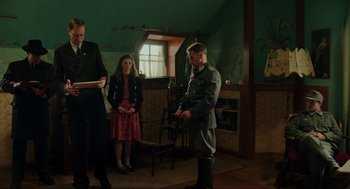 Movie still from “Jojo Rabbit” (2019), directed by Taika Waititi – Two men and a woman standing in a living room; Medium shot, Low angle