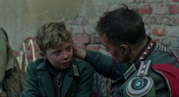 Movie still from “Jojo Rabbit” (2019), directed by Taika Waititi – A young boy is getting help from an older man; Close Up shot, Over the shoulder angle