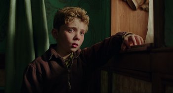 Movie still from “Jojo Rabbit” (2019), directed by Taika Waititi – A young boy leaning against a wall with his hand on his shoulder; Close Up shot, Over the shoulder angle