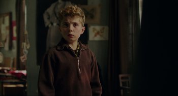 Movie still from “Jojo Rabbit” (2019), directed by Taika Waititi – A young boy in a brown sweater looking at the camera; Close Up shot, Over the shoulder angle