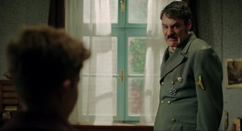 Movie still from “Jojo Rabbit” (2019), directed by Taika Waititi – A man in a military uniform looking angry at a woman; Medium shot, Over the shoulder angle