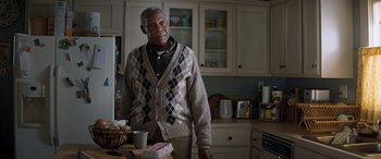 Movie still from “Jumanji: The Next Level” (2019), directed by Jake Kasdan – An older man standing in a kitchen next to a counter; Medium shot, Low angle