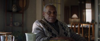 Movie still from “Jumanji: The Next Level” (2019), directed by Jake Kasdan – An older man sitting at a table with a cup of coffee; Close Up shot, Low angle