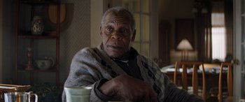 Movie still from “Jumanji: The Next Level” (2019), directed by Jake Kasdan – An older man sitting at a table with a cup of coffee; Close Up shot, Low angle