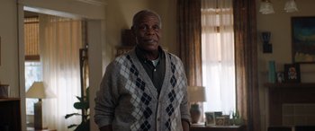 Movie still from “Jumanji: The Next Level” (2019), directed by Jake Kasdan – An older man standing in front of a window in a room; Medium shot, Over the shoulder angle