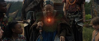 Movie still from “Jumanji: The Next Level” (2019), directed by Jake Kasdan – An older woman is holding a pipe in her hands; Medium shot, Over the shoulder angle