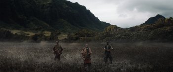 Movie still from “Jumanji: The Next Level” (2019), directed by Jake Kasdan – A group of men standing on top of a grass covered field; Extreme Wide shot, High angle
