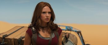 Movie still from “Jumanji: The Next Level” (2019), directed by Jake Kasdan – A woman in a red shirt is standing in front of a truck; Close Up shot, Over the shoulder angle