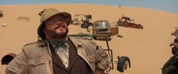 Movie still from “Jumanji: The Next Level” (2019), directed by Jake Kasdan – A man with a beard and a hat standing in the desert; Close Up shot, Over the shoulder angle