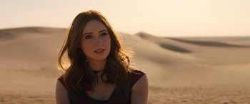 Movie still from “Jumanji: The Next Level” (2019), directed by Jake Kasdan – A beautiful woman standing on top of a sandy beach; Close Up shot, Over the shoulder angle