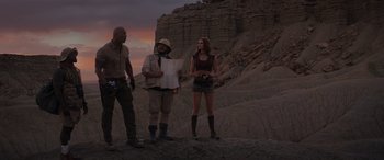 Movie still from “Jumanji: The Next Level” (2019), directed by Jake Kasdan – A group of people standing on top of a hill; Wide shot, Over the shoulder angle