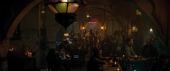 Movie still from “Jumanji: The Next Level” (2019), directed by Jake Kasdan – A group of people sitting at a table in a room; Wide shot, Over the shoulder angle
