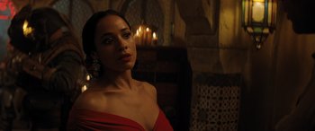 Movie still from “Jumanji: The Next Level” (2019), directed by Jake Kasdan – A woman in a red dress in front of candles; Close Up shot, Over the shoulder angle