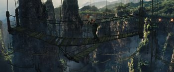 Movie still from “Jumanji: The Next Level” (2019), directed by Jake Kasdan – A man standing on top of a bridge over a river; Extreme Wide shot, High angle