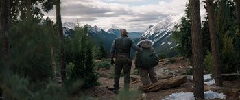 Movie still from “Jumanji: The Next Level” (2019), directed by Jake Kasdan – Two people standing on top of a hill with backpacks; Wide shot, Over the shoulder angle