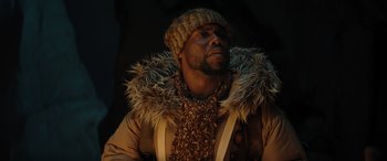 Movie still from “Jumanji: The Next Level” (2019), directed by Jake Kasdan – A man wearing a hat and a fur coat; Close Up shot, Low angle